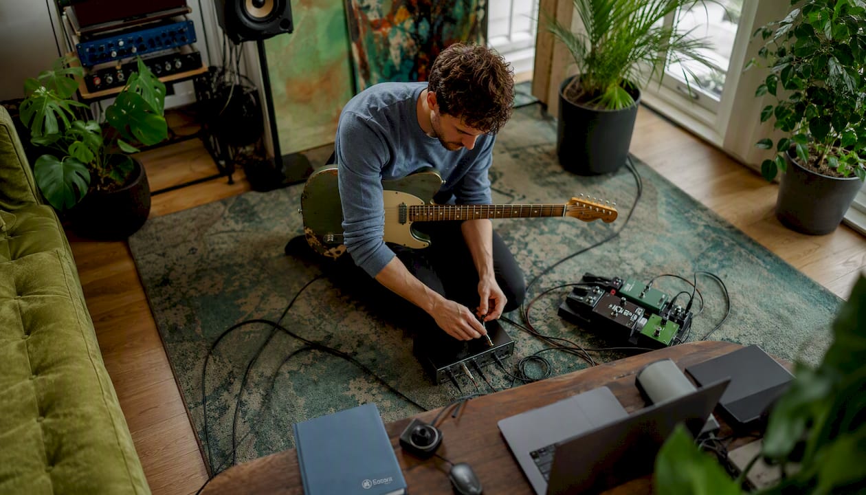 Man sluit audio-interface aan in zijn thuisstudio