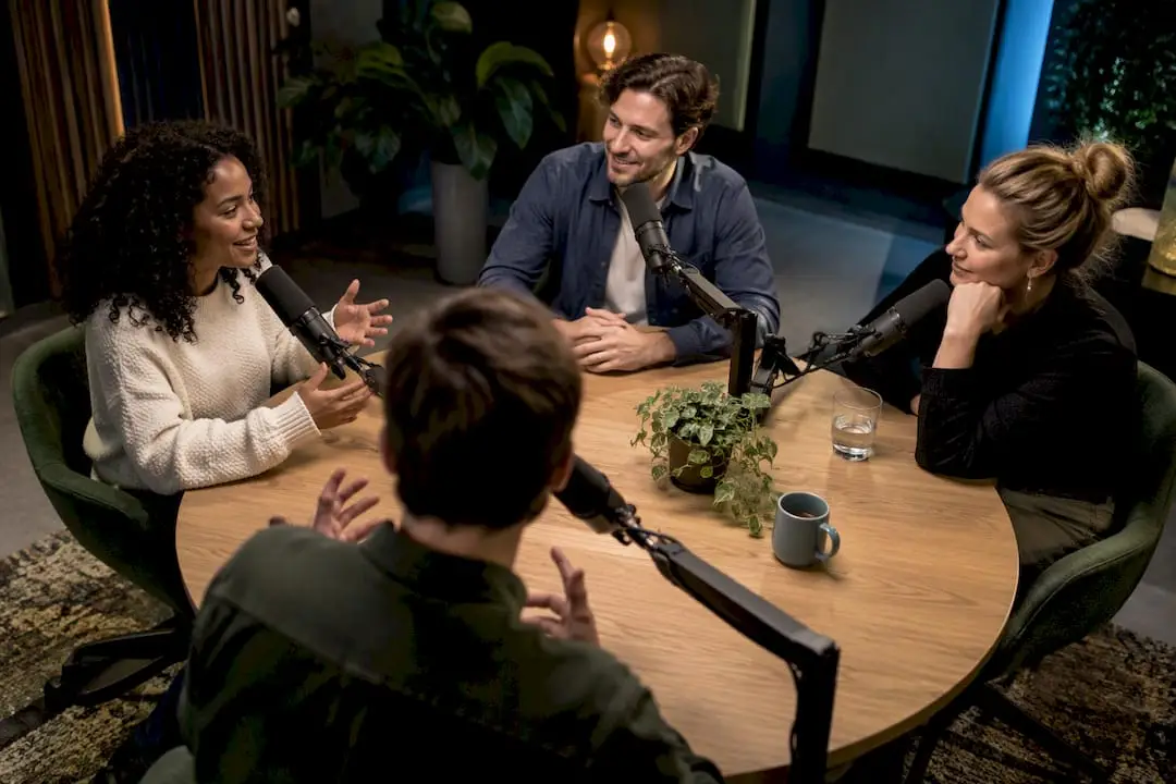 Quatre personnes dans un studio de podcast professionnel