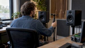 Microphone de mesure placé entre deux enceintes de studio étalonnées
