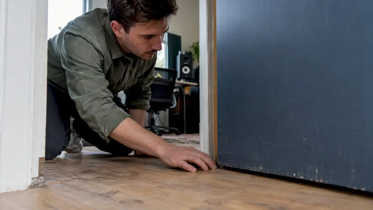 Détecter les fuites sonores dans votre studio : méthode et conseils de mesure 3 Le propriétaire du studio jette un coup d'œil par la fente de la porte